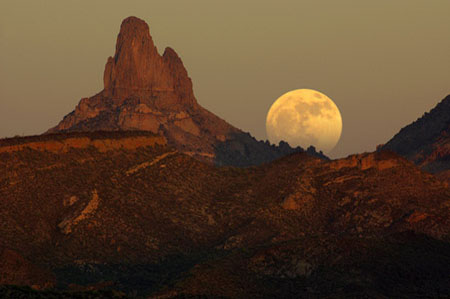 Full moon rising behind Weaver's Needle in the Superstition Mountains